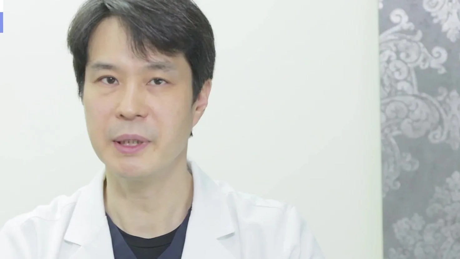 흰 가운을 입은 의사가 정면을 보며 설명하는 모습