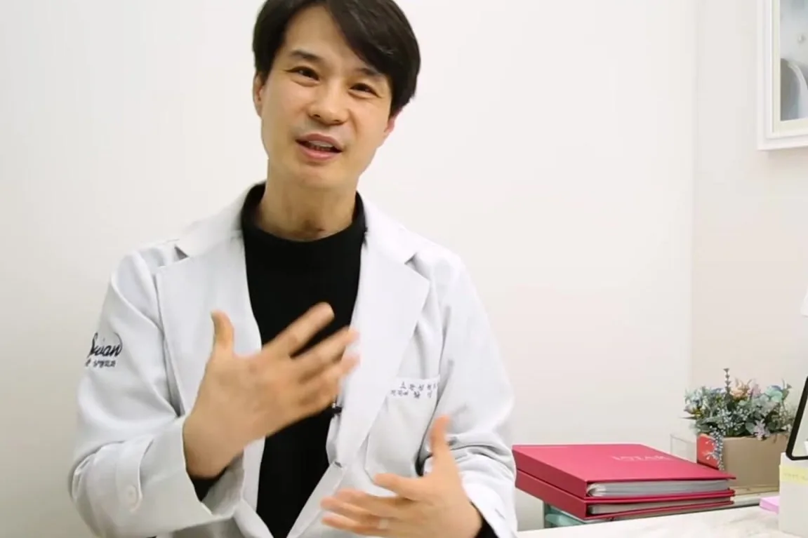 흰 가운을 입은 의사가 상담실에서 손짓을 하며 설명하는 모습