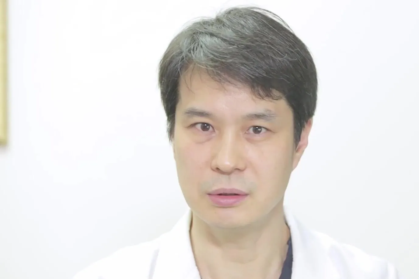 흰 가운을 입은 의사가 정면을 보며 설명하는 모습