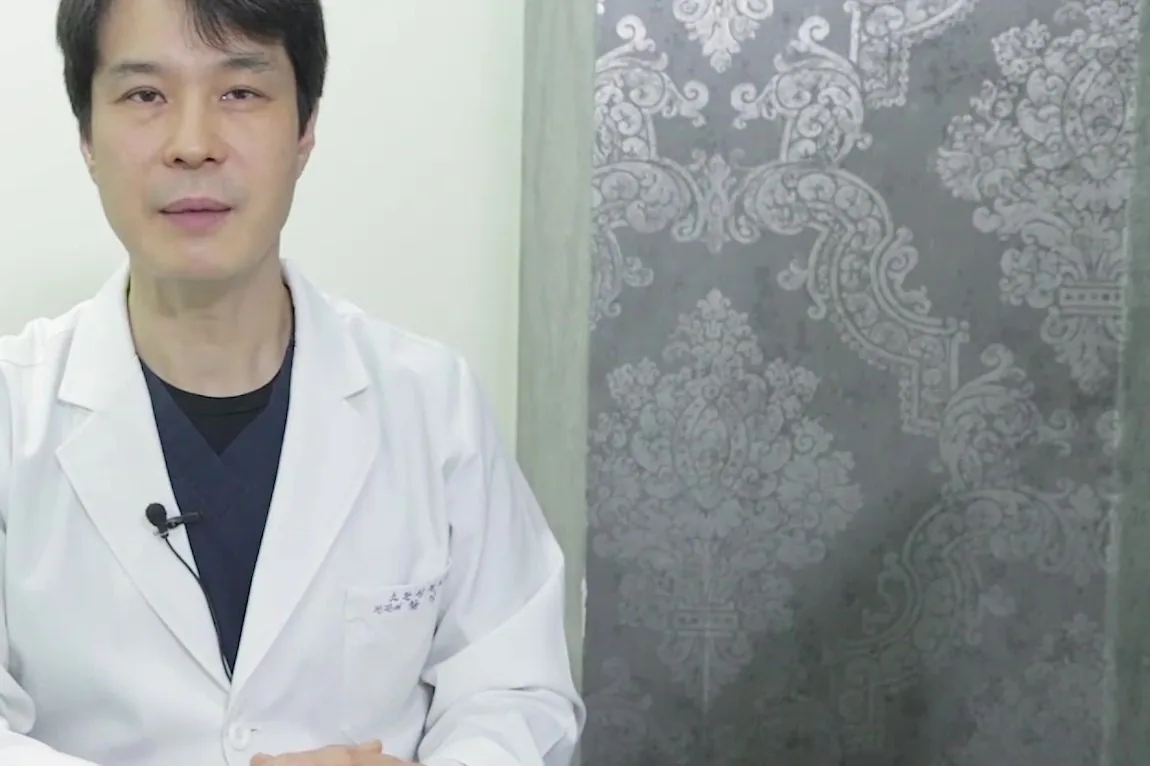 상담실에서 흰 가운 차림 의사가 정면을 보며 말하는 장면